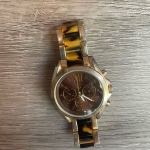 Women’s watch tortoise design watch and face.